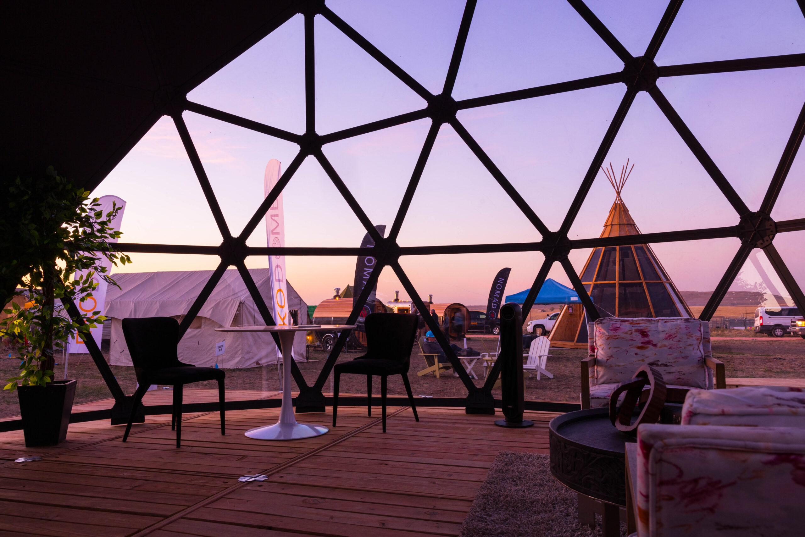 glamping-show-2024-104 The unique and varied glamping structures at Glamping Show Americas at sunset, viewed from inside an Ekodome.