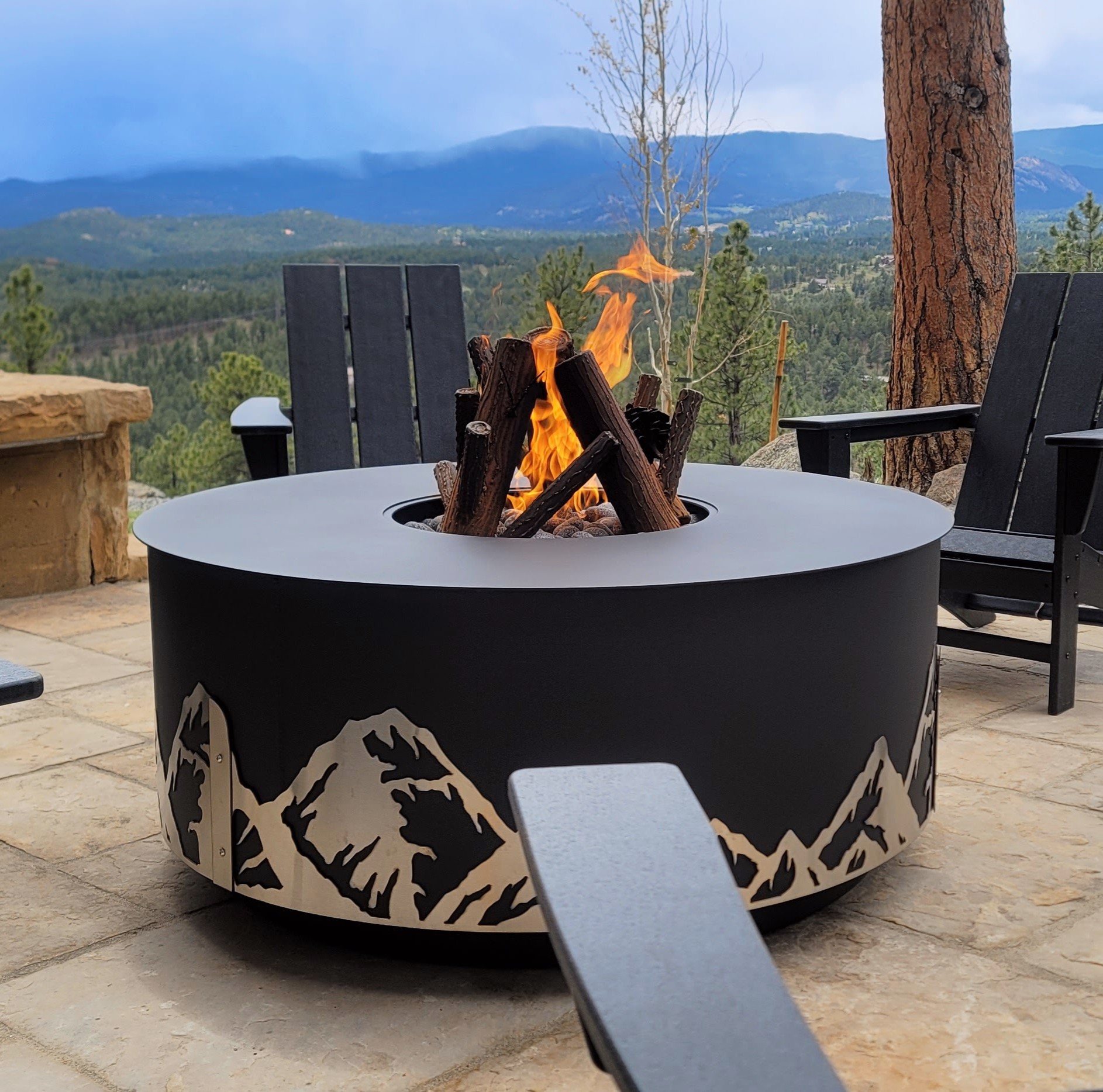 Colorado Fire Pit 3 Colorado Fire Pit is ablaze surrounded by Adirodak chairs with a beautiful vista in the background.