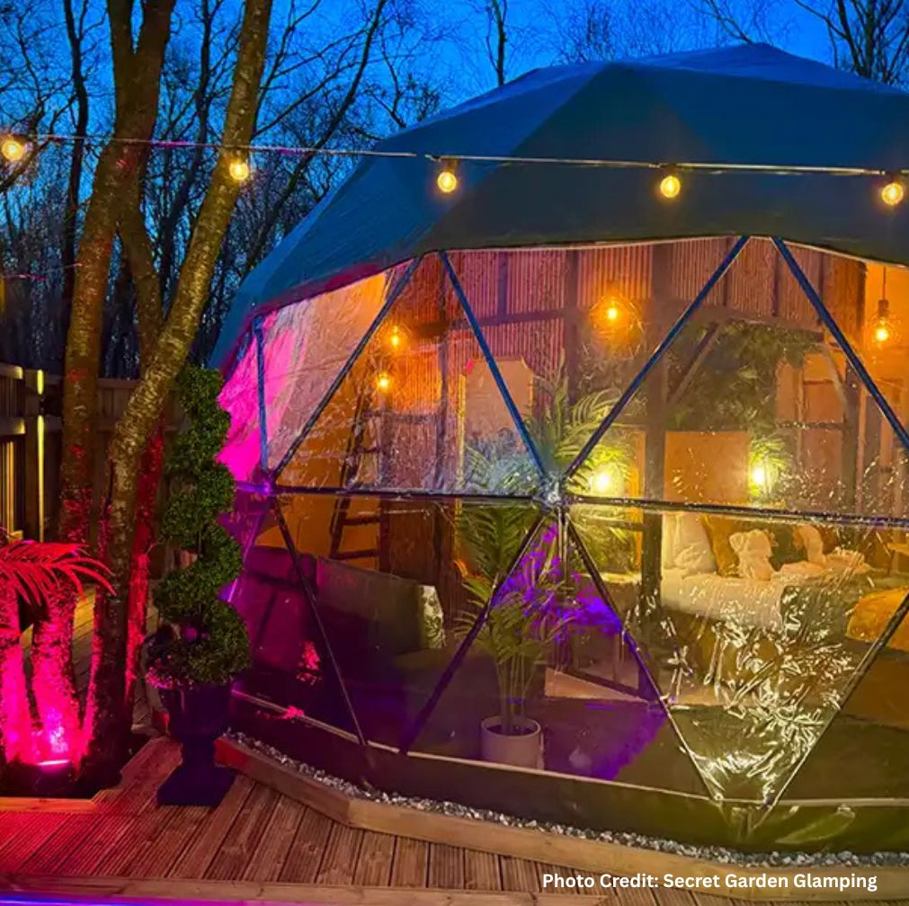 Warmly lit dome from Secret Garden Glamping at night.