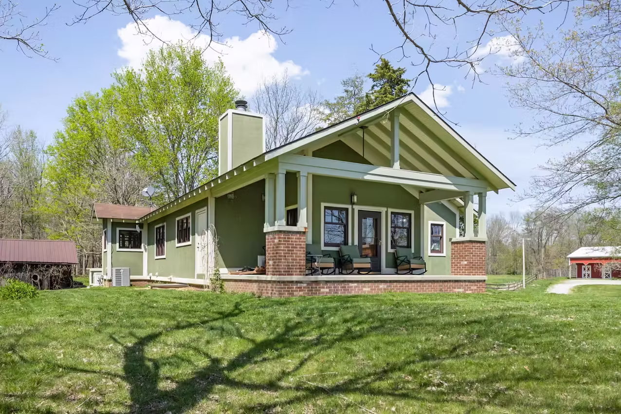 Exterior of a spacious farmhouse on a sunny Indiana day.