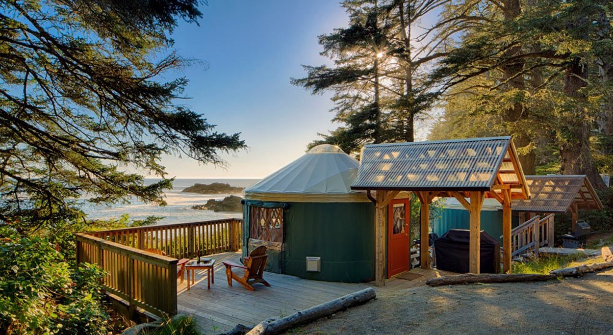 Pacific Yurt accommodations on a wooded coastal property, with yurts and covered decks overlooking the ocean.
